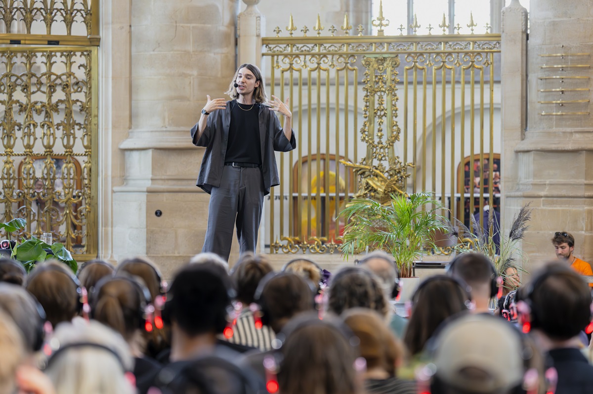 Ed Winters op een podium inde Laurenskerk terwijl hij een inspirerende lezing geeft.