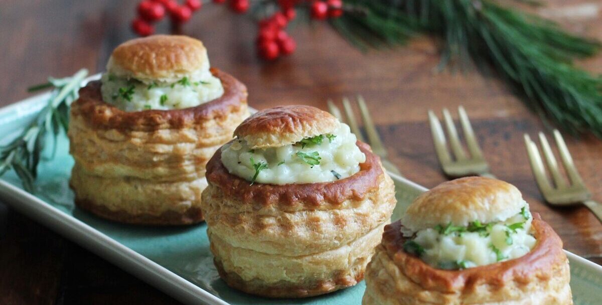 Drie pasteitjes met bloemkoolragout. Op de achtergrond een kersttak met rode bessen.