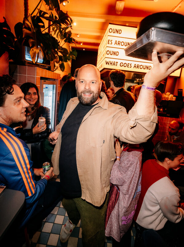 Pascal Labrie loopt met een dienblad door zijn volle restaurant